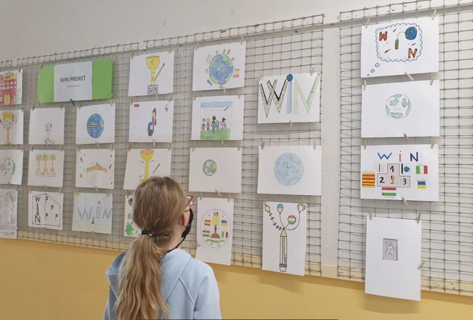 Una nena observa les propostes de logotip del projecte WIN
